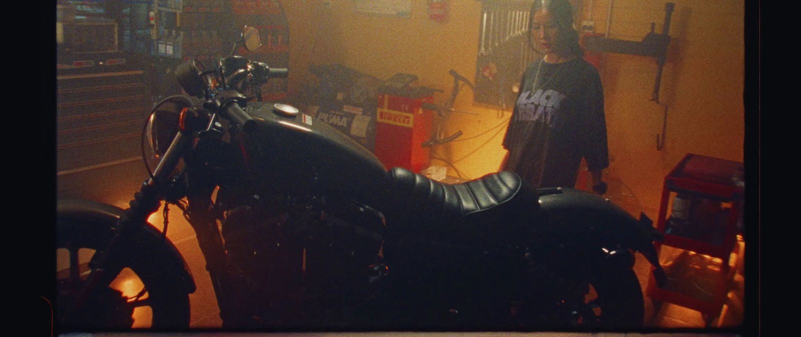 a motorcycle parked in a garage next to a man