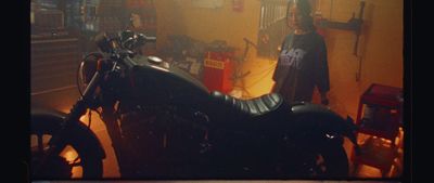 a motorcycle parked in a garage next to a man