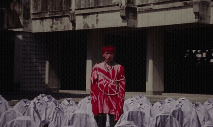 a man standing in front of a bunch of white shirts