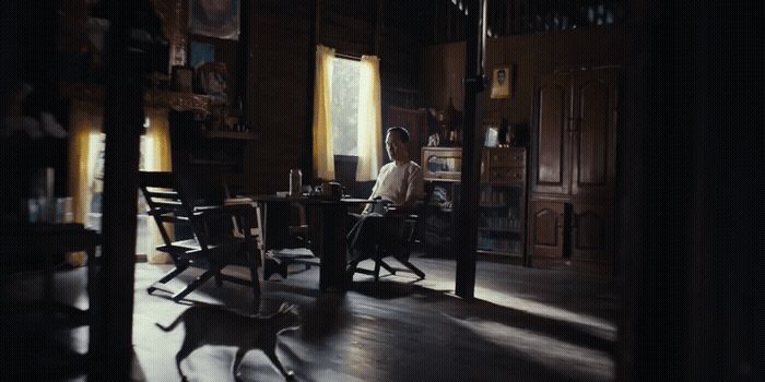 a woman sitting at a table in a dark room