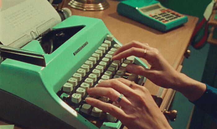 a person typing on an old fashioned typewriter