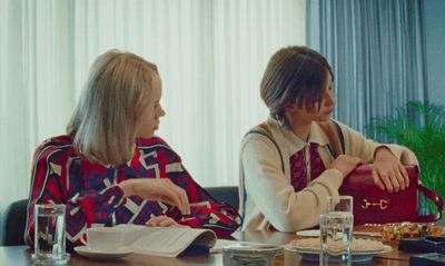 two women sitting at a table talking to each other