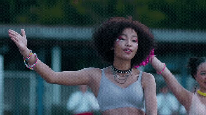 two young women are dancing with their hands in the air