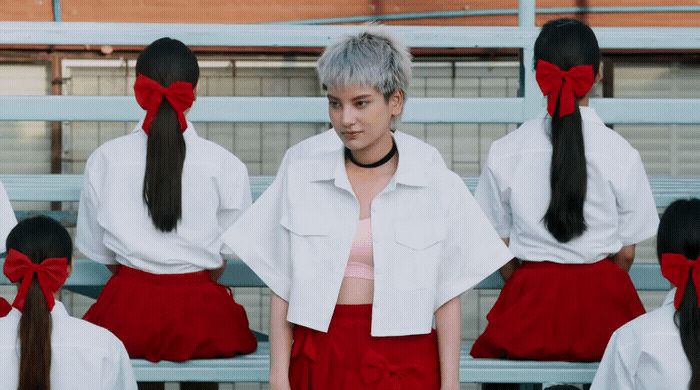 a woman with grey hair standing in front of a group of girls