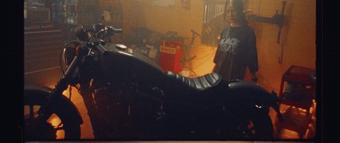 a man standing next to a motorcycle in a garage