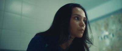 a woman with long black hair standing in a bathroom