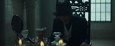 a man in a top hat sitting at a table