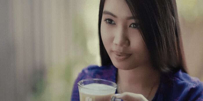 a woman is holding a glass of milk