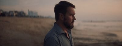 a man with a beard standing in a field