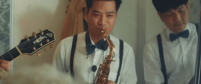 a man playing a saxophone in front of a mirror