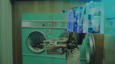 a person is holding a basket in front of a washing machine