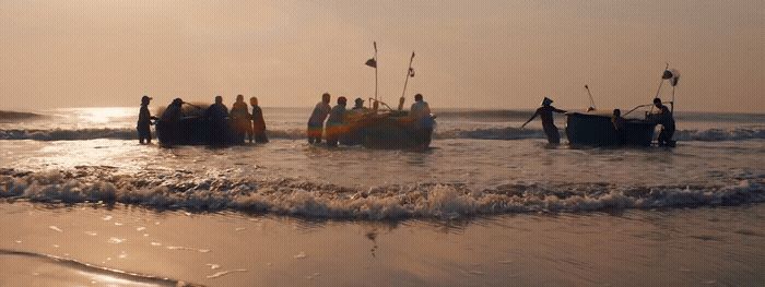 a group of people standing on top of a boat in the ocean