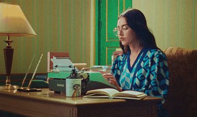 a woman sitting at a desk with an open book