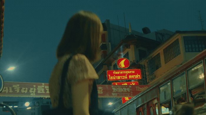 a woman walking down a street at night