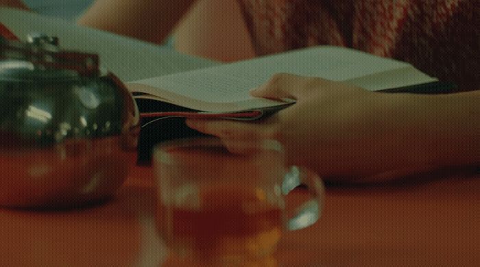 a person sitting at a table reading a book