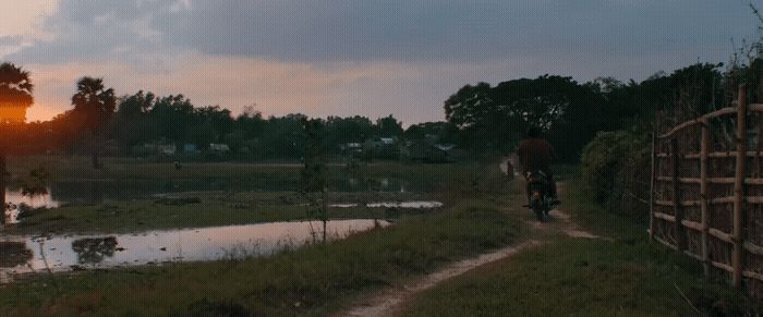 a man riding a bike down a dirt road