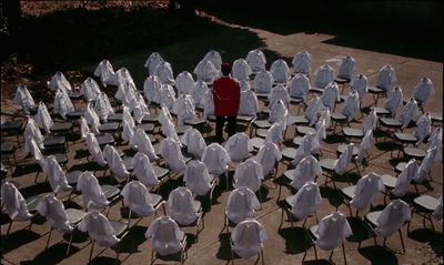 a man standing in front of a large group of white chairs