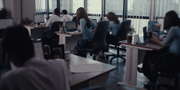 a group of people sitting at desks in an office