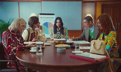 a group of people sitting around a wooden table