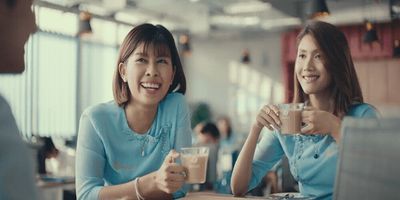 a woman sitting at a table with a glass of milk