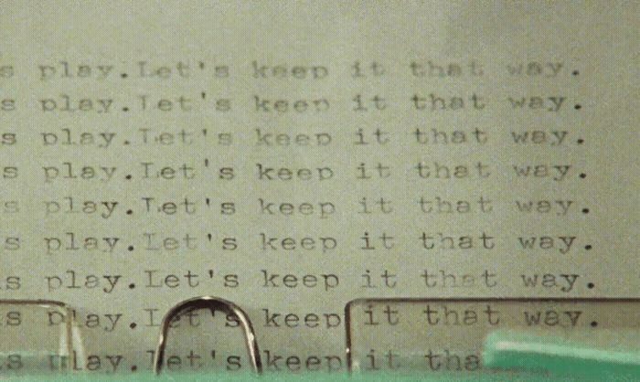 a close up of a typewriter with a paper clip