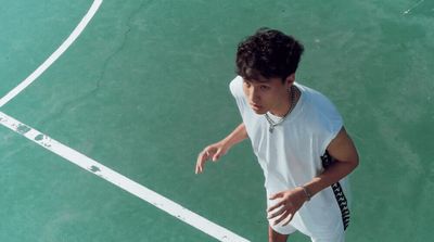 a man standing on a tennis court holding a racquet