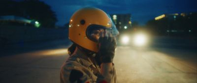 a person wearing a helmet standing on a street at night