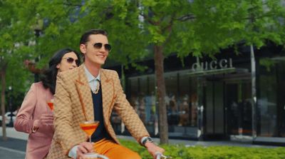 a man and woman riding a bike down a street