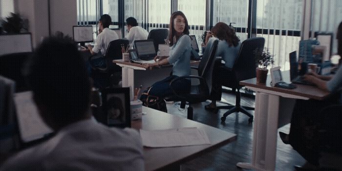 a group of people sitting at desks in an office