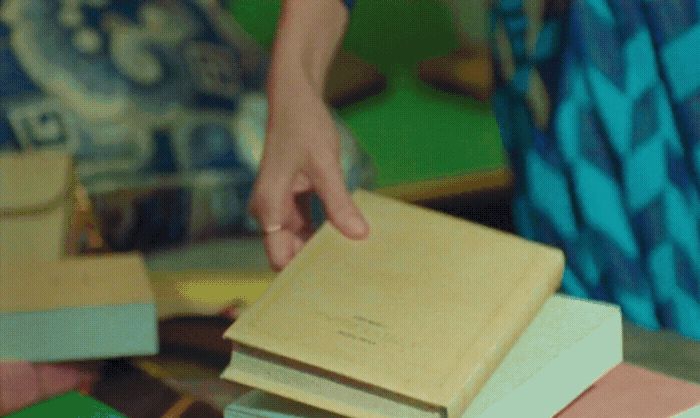 a person reaching for a book on a table