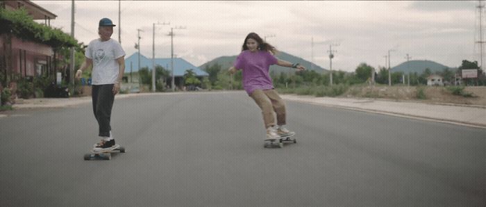 a couple of people riding skateboards down a street