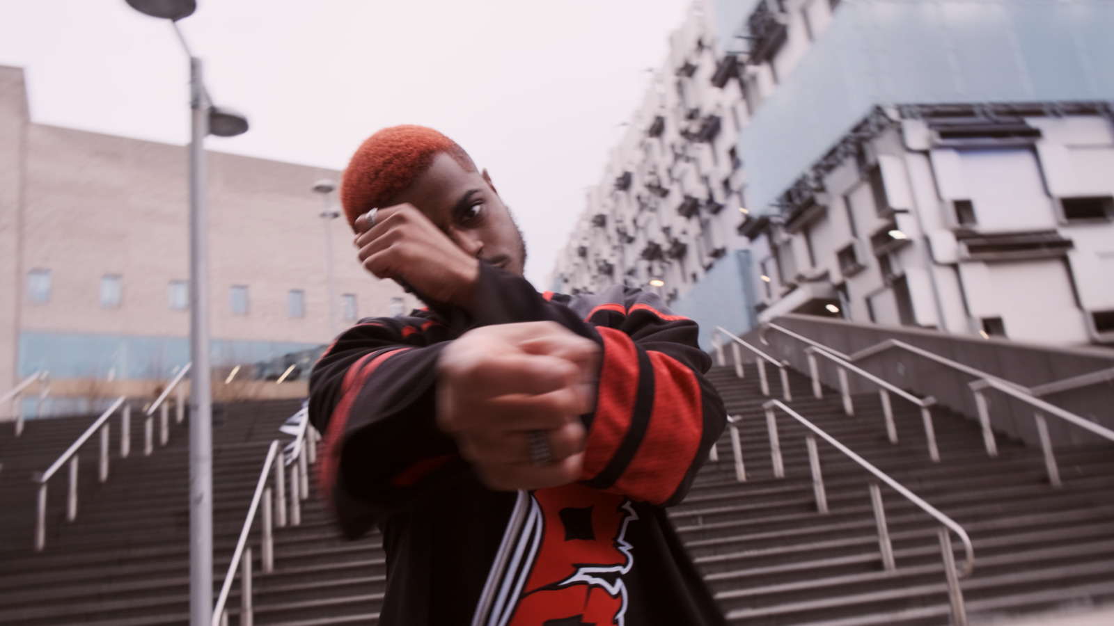 a man with a red hat pointing a gun at the camera