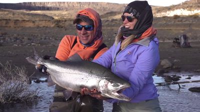 a couple of women holding a large fish