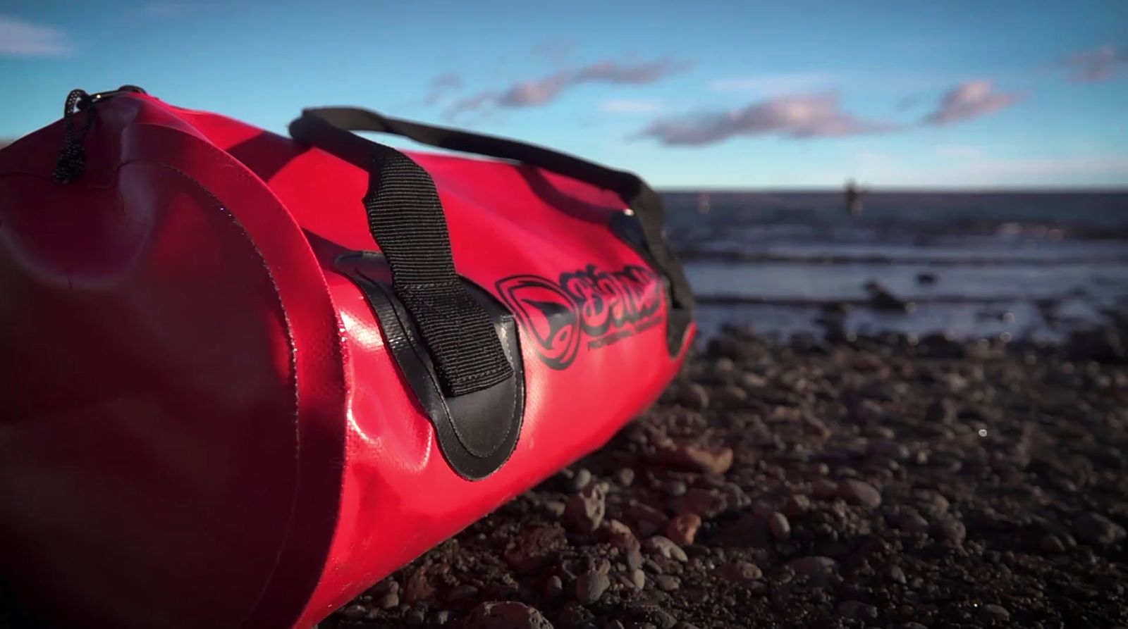 a red bag sitting on top of a rocky beach