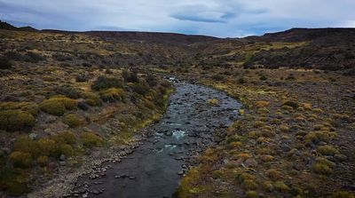 a river running through a lush green hillside