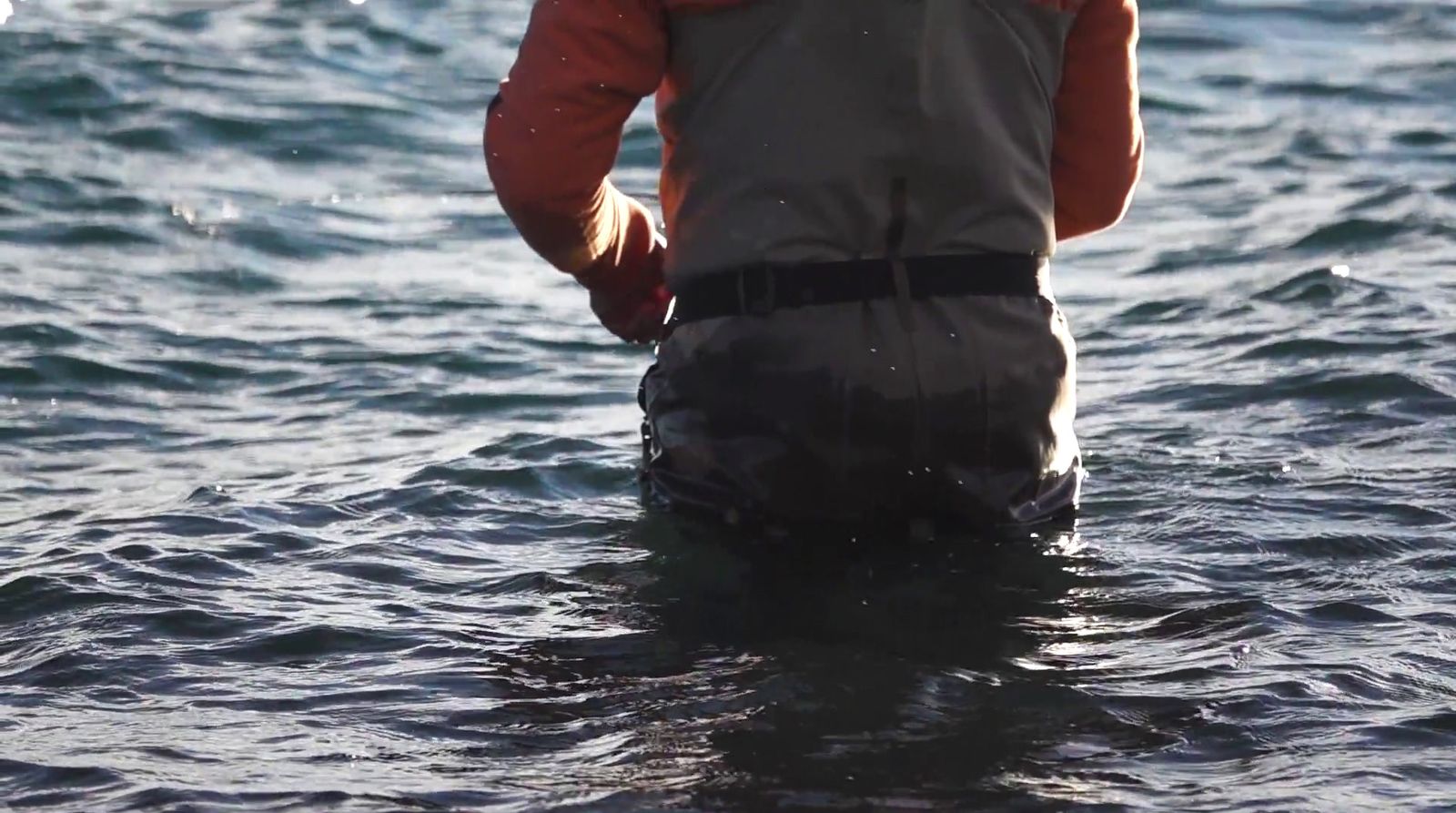 a man standing in a body of water wearing a life jacket