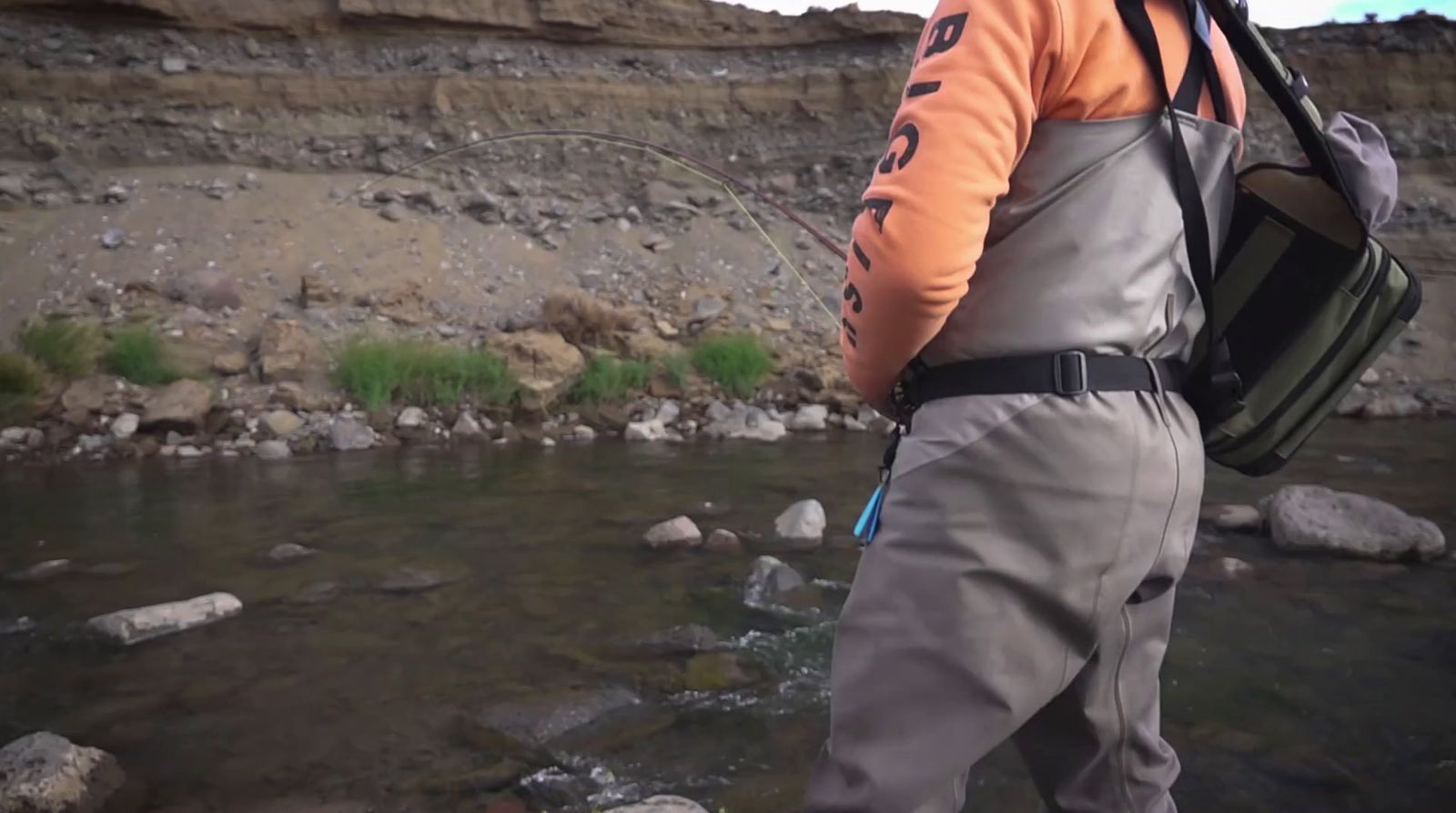 a man with a backpack standing in a river