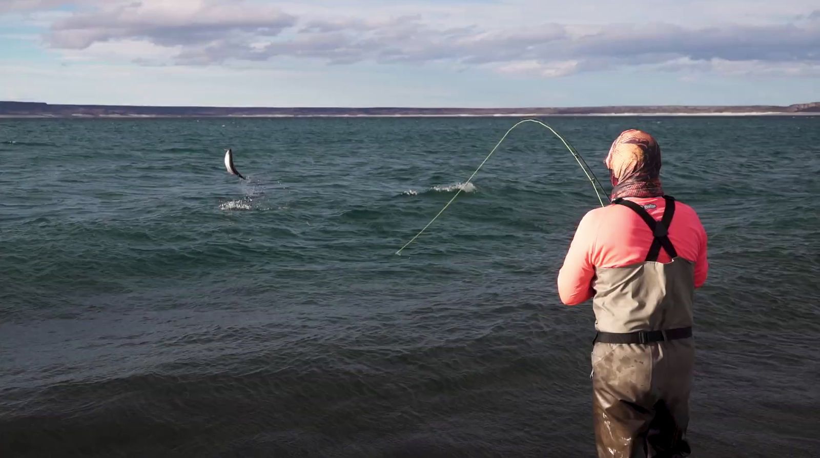 a man standing on a beach while fishing