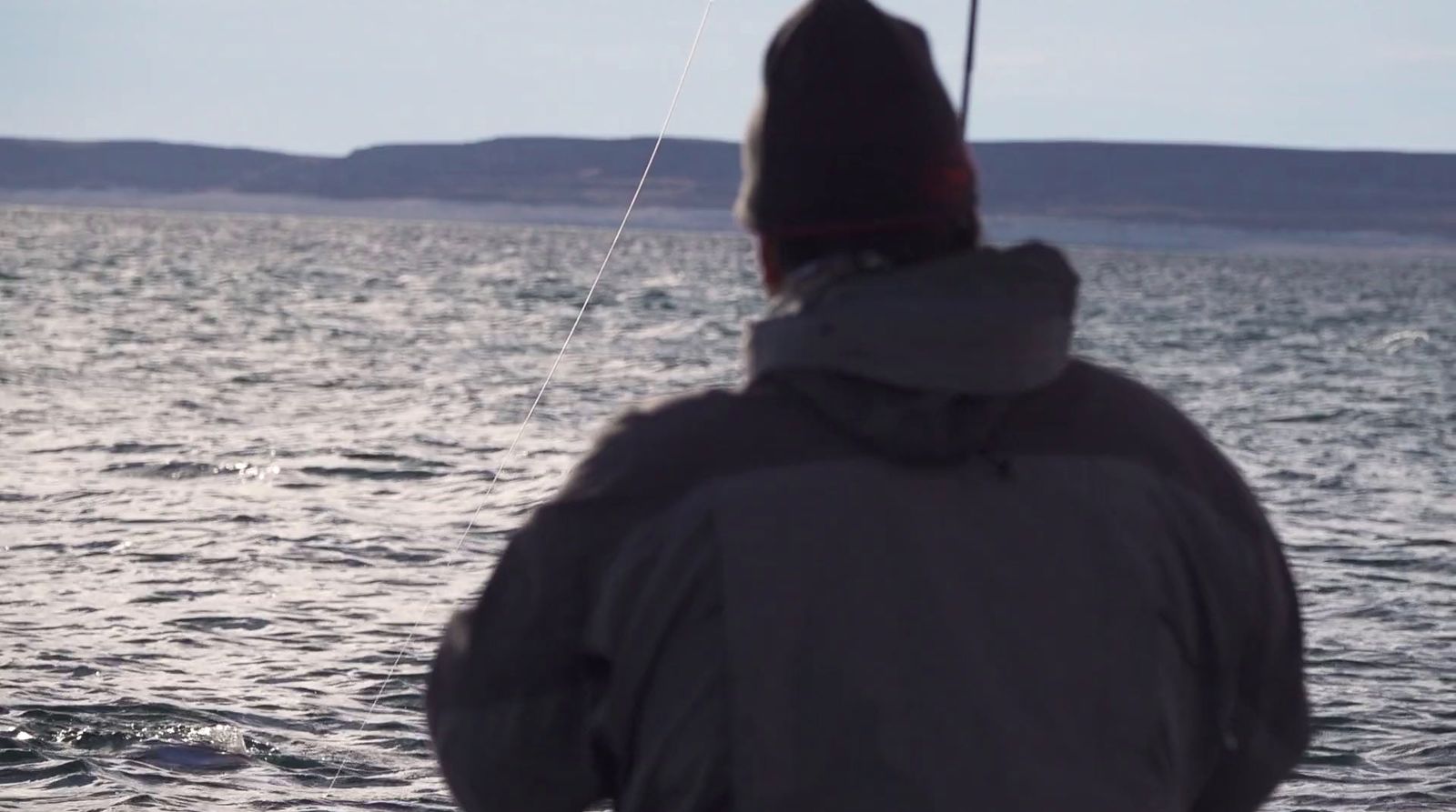 a person standing in the water with a kite