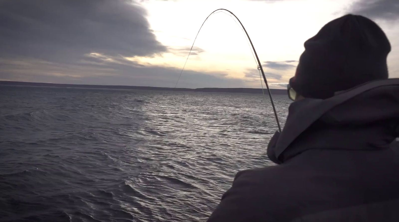 a person on a boat with a fishing rod