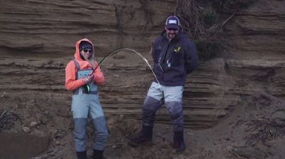 a man and a woman standing in front of a cliff