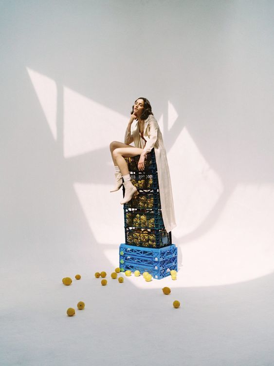 a woman sitting on top of a stack of crates