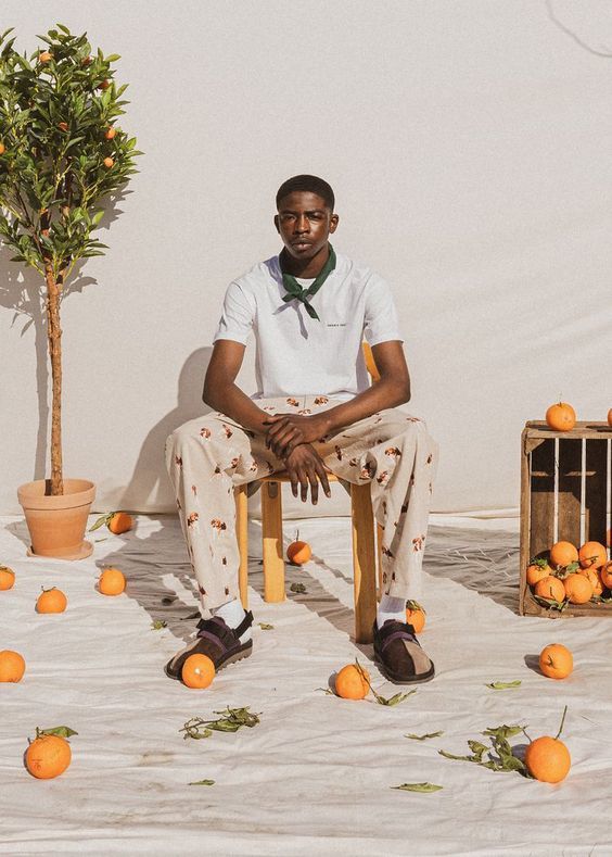 a man sitting on a chair surrounded by oranges