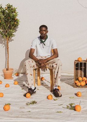 a man sitting on a chair surrounded by oranges