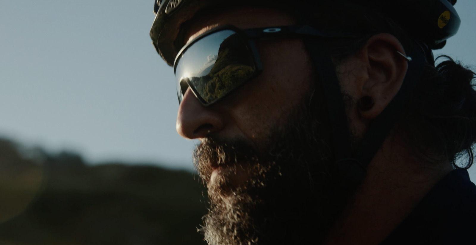 a man with a beard wearing a helmet and sunglasses