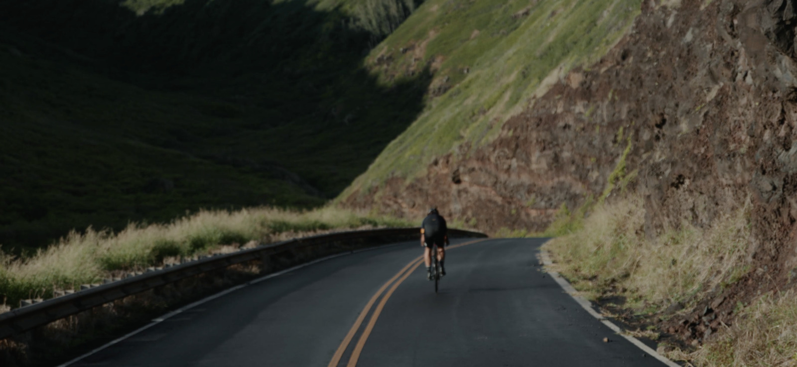 a man riding a bike down a curvy road