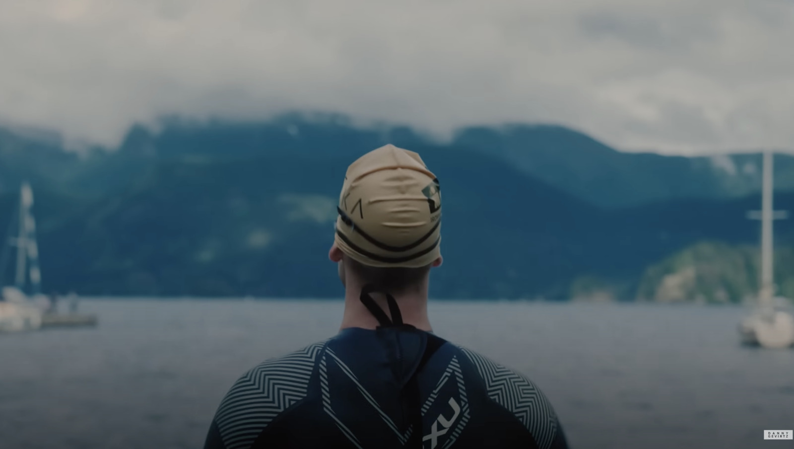 a man wearing a hat looking out over a body of water