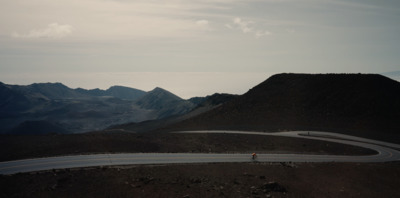 a person walking on a winding road in the mountains