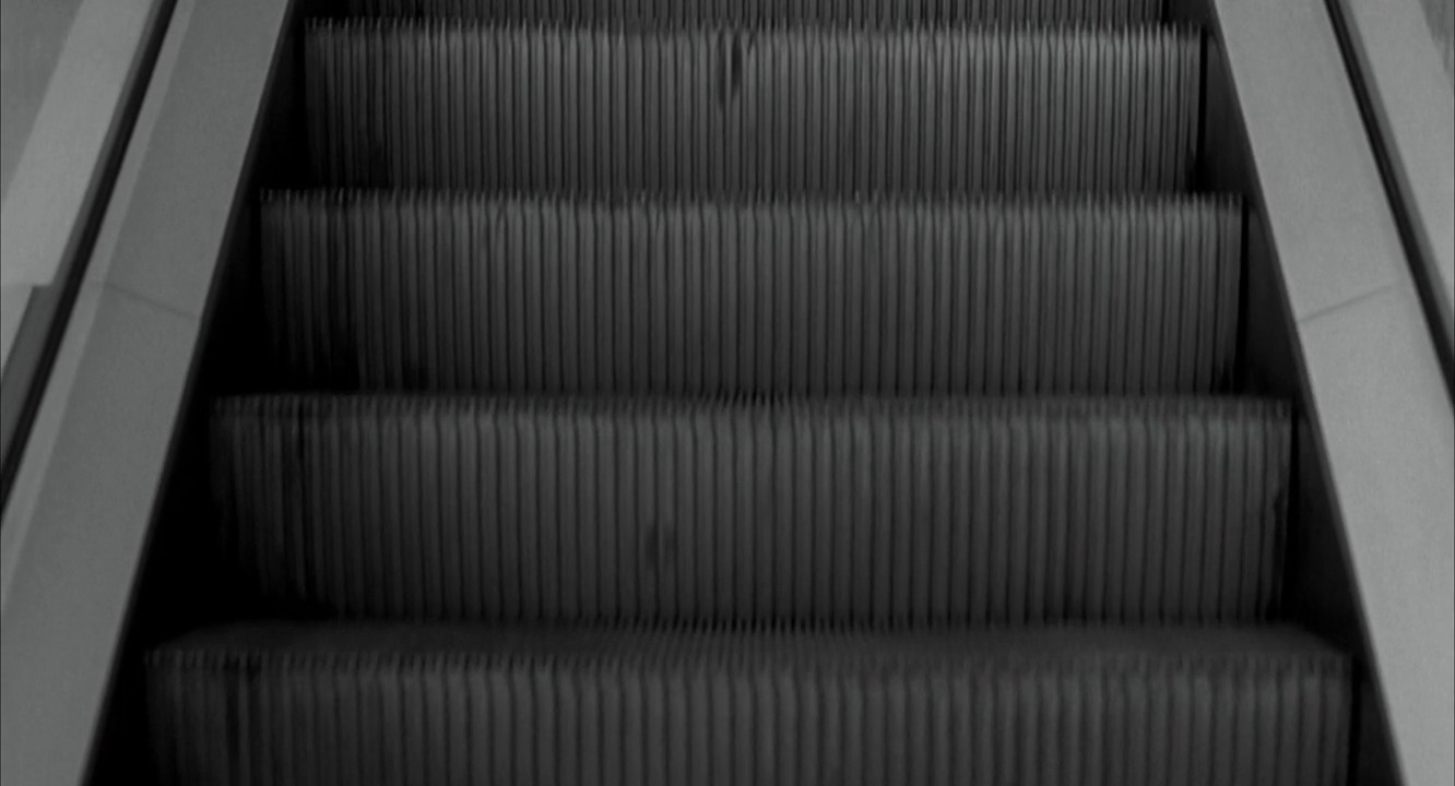 a black and white photo of an escalator