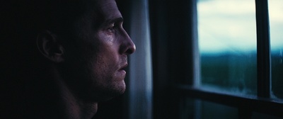 a man looking out of a window in the dark